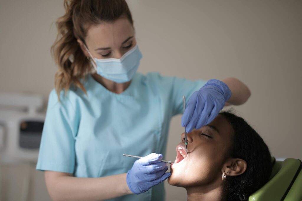 A professional dentist examines a patient's teeth in a modern clinic.