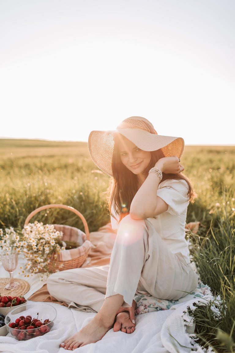 A woman enjoying a romantic picnic surrounded by nature and sunshine.
