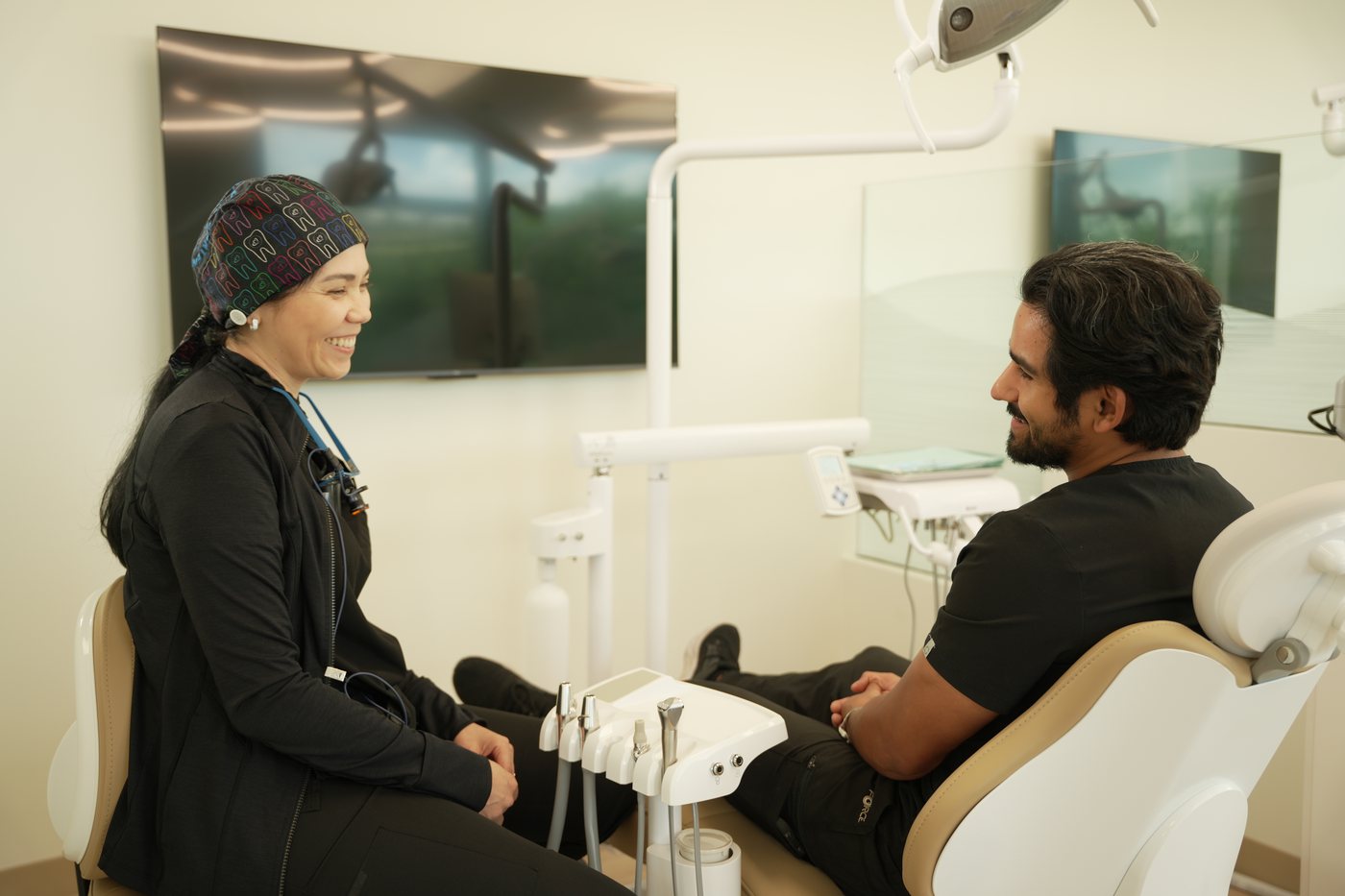 A clinician talking with a patient in the treatment chair