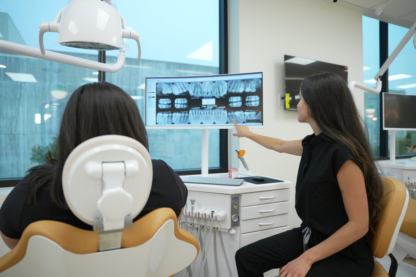 A team member showing a patient her X-rays on screen
